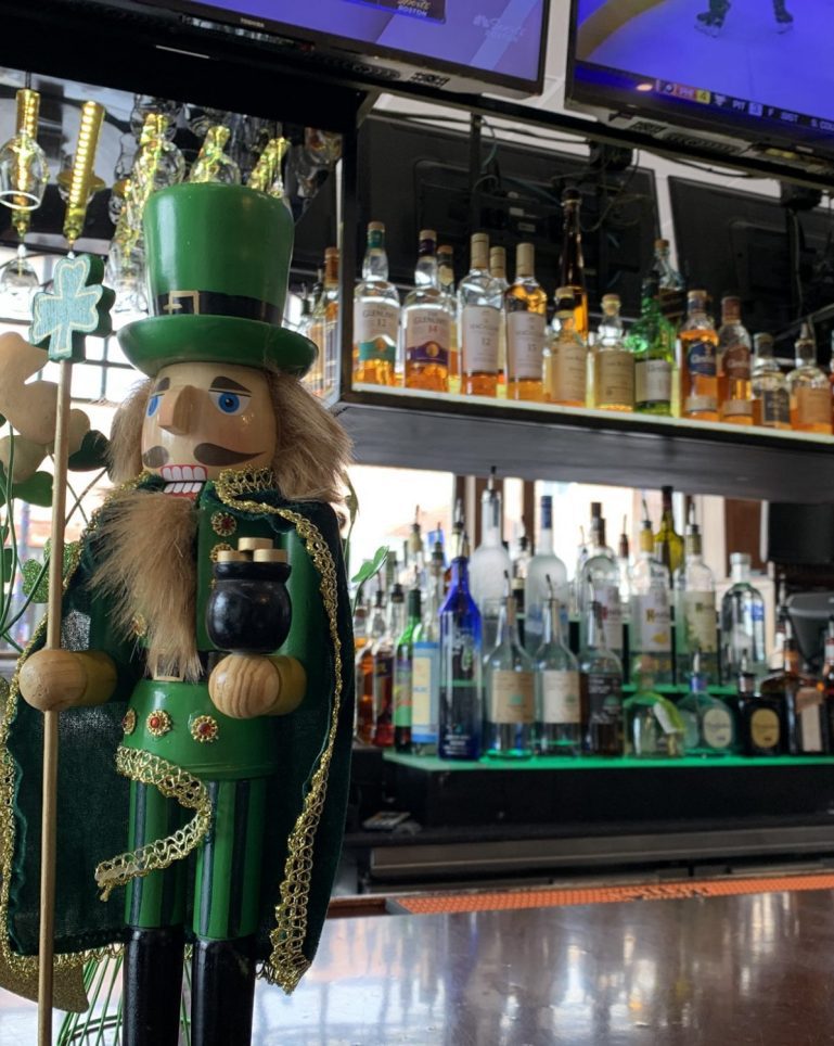 St. Patrick's Day nutcracker on a bar with liquor in the background