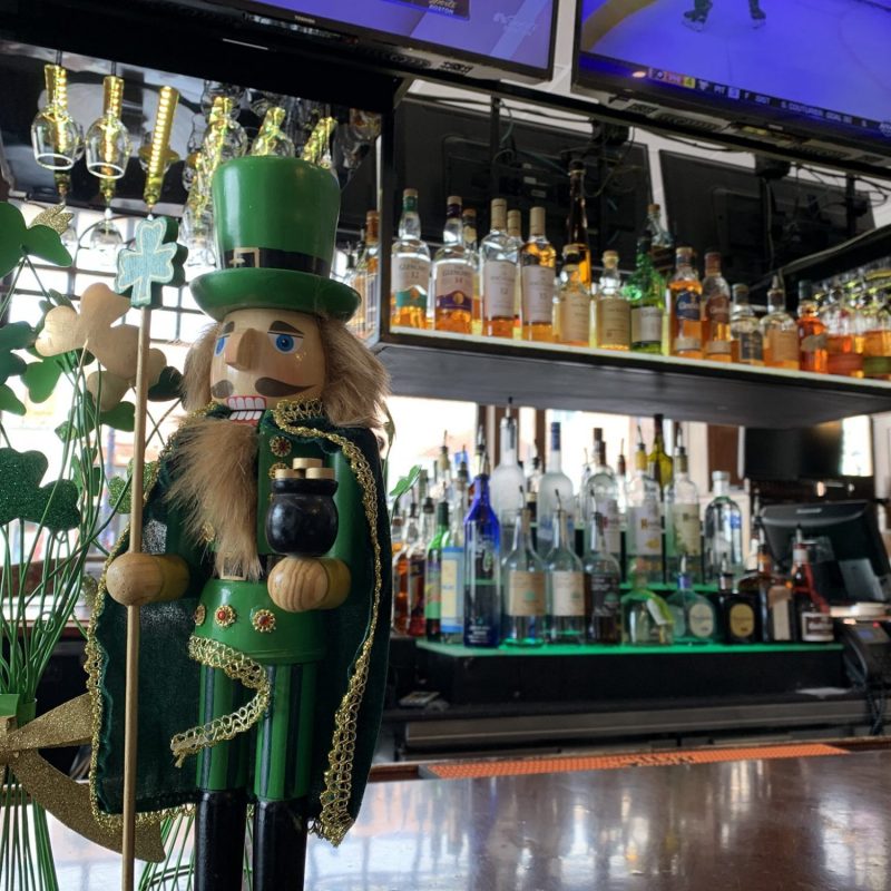 St. Patrick's Day nutcracker on a bar with liquor in the background