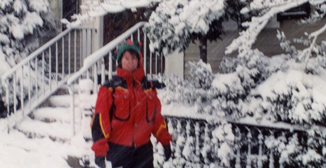 Person in red jacket walking down a snowy Salem street