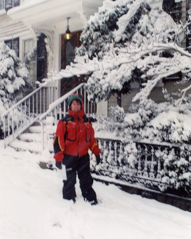 Person in red jacket walking down a snowy Salem street