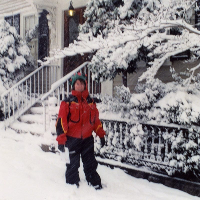 Person in red jacket walking down a snowy Salem street